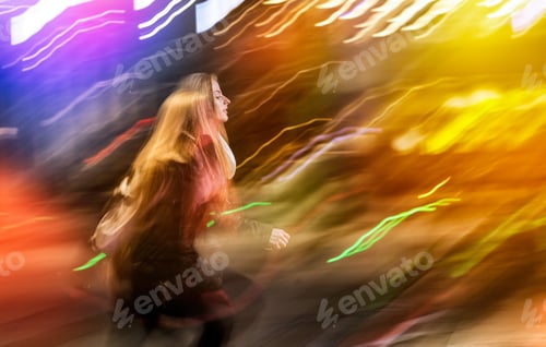 Preview: Woman in city at night among neon moving lights