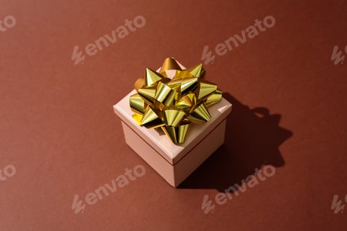 Preview: Gift box with golden bow on brown