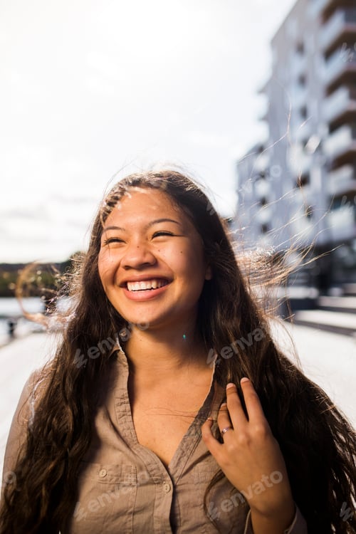 Preview: Happy young woman looking away outdoors