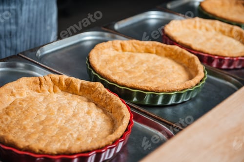 Preview: Cooked pie bases in baking pans on the kitchen