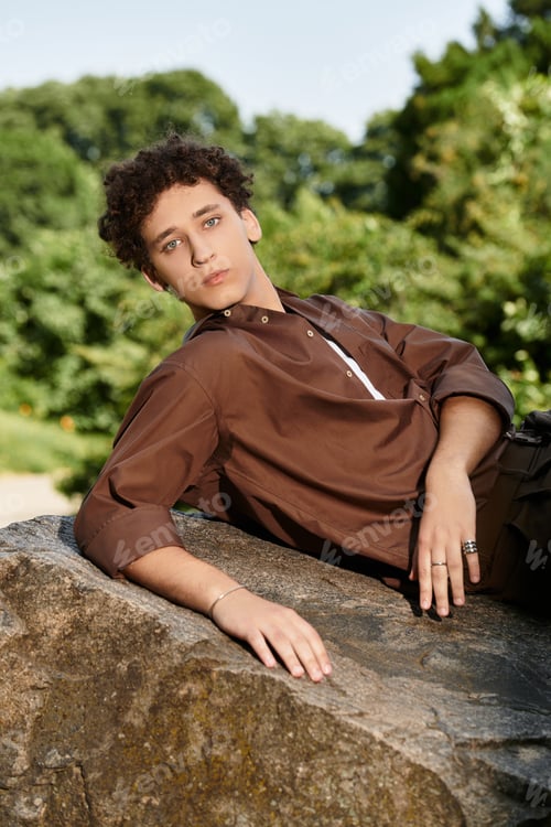 Preview: Curly haired young man enjoying a tranquil day in a vibrant summer park