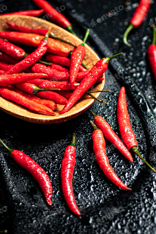 Preview: Pods of hot chili peppers on a cutting board.