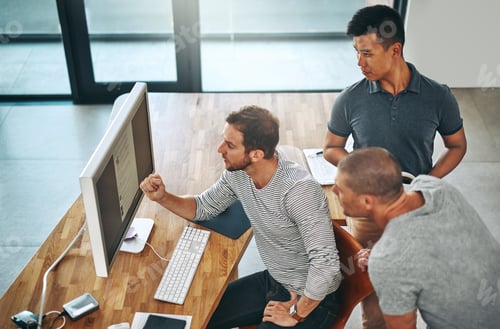 Preview: High angle shot of three designers working together on a project in an office