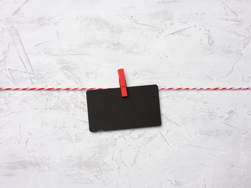 Preview: Blank black cardboard rectangular sheet of paper hang on clothespins