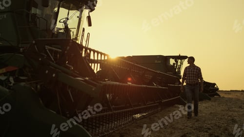 Preview: Farmer walking combine harvester working on beautiful countryside field.