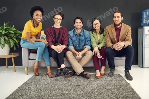 Preview: Portrait of a group of young creatives sitting together on a couch in an office