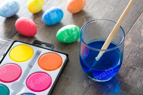 Preview: Painting easter eggs on wooden table with watercolors and brush
