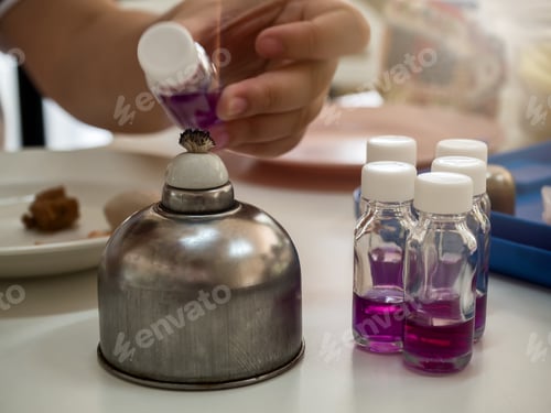Preview: Close-up of bottle being sterilized with an alcohol burner before use in bacterial cultures.