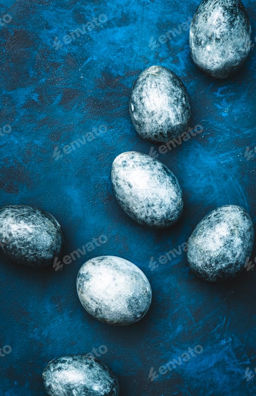 Preview: Easter composition with blue painted eggs on blue background, top view