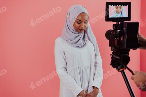 Preview: Videographer in digital studio recording video on professional camera by shooting female Muslim