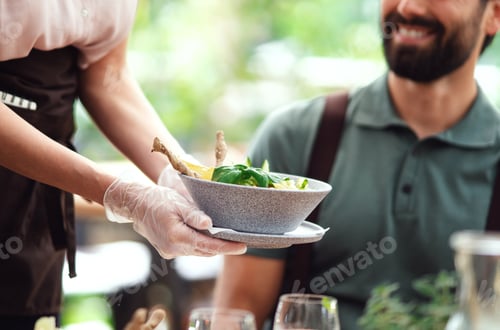 Preview: Unrecognizable waitres with gloves serving man outdoors on terrace restaurant