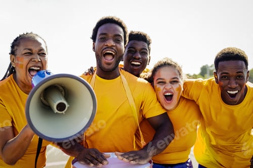 Preview: African yellow football fans celebrate in the crowd watching the game at sport stadium