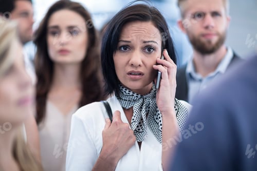 Preview: Annoyed woman on cell phone in busy city