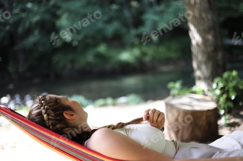 Preview: Woman Relaxing in a Hammock Near The Water