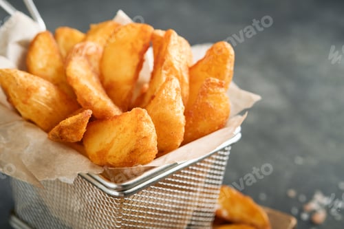 Preview: French fries in metal wire basket with salt and ketchup on old wooden dark background clous up. Frie