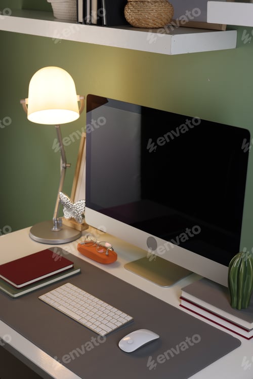 Preview: Stylish workplace with computer and grey mat on desk in office, closeup