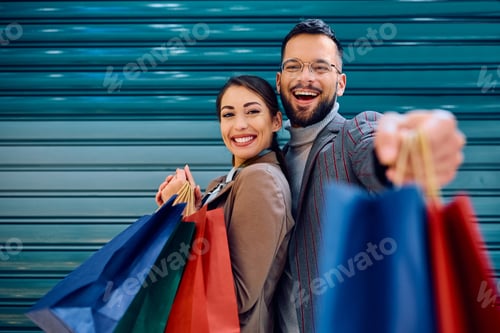 Preview: Carefree couple having fun during shopping and looking at camera.