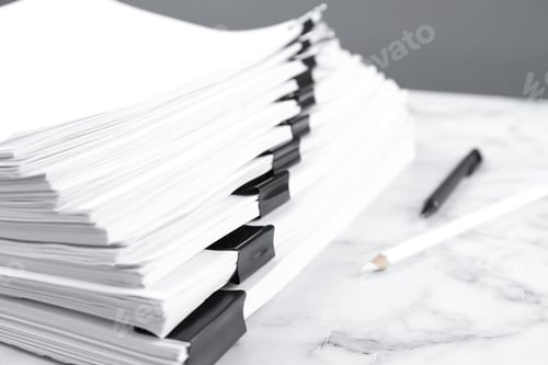 Preview: Stack of documents with binder clips on marble table, closeup