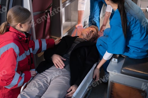 Preview: cropped image of paramedics moving unconscious man into ambulance