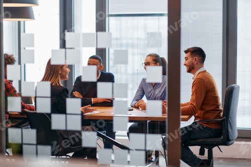 Preview: In a sleek glass office space, a team of business professionals engage in lively discussions and