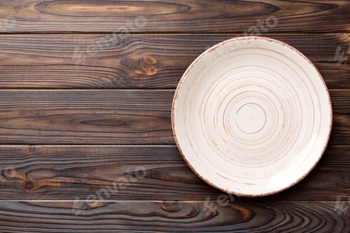 Preview: Top view of empty colorful plate on wooden background. Empty space for your design