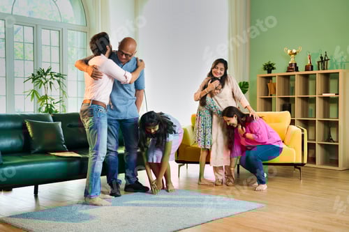 Preview: Multigenerational Indian family sharing heartfelt hugs as kids respectfully greet their grandparents