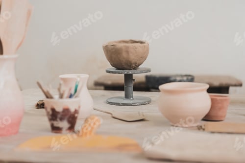 Preview: sculpted clay bowl on wooden table in pottery art studio