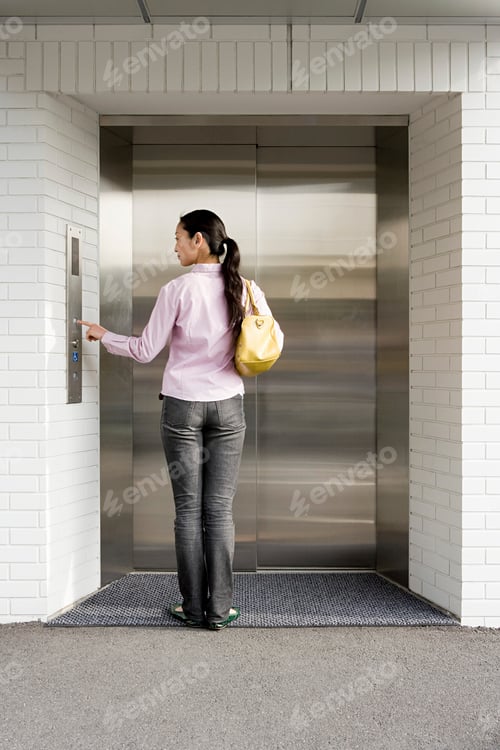 Preview: Woman patiently waiting for the elevator.