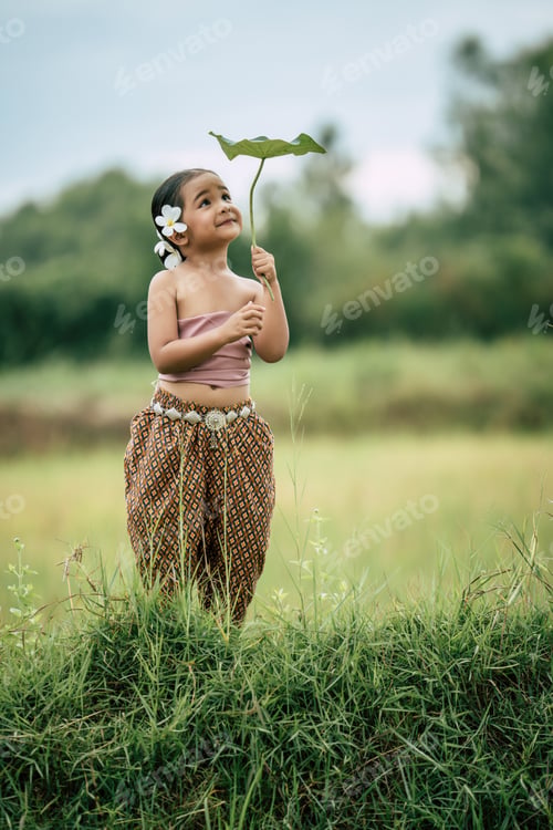 Preview: Cute girls in Thai traditional dress holding leaf of lotus