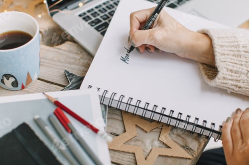 Preview: Woman writing plans for Monday in empty notebook. Workplace. Winter holidays