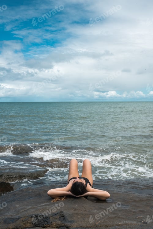 Preview: latin woman sunbathing on the beach in australia