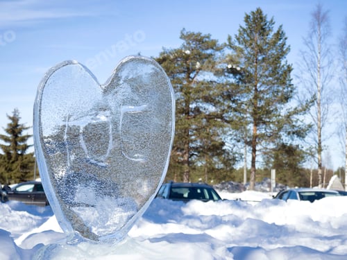 Preview: An ice heart in glittering snow with shallow depth of field.