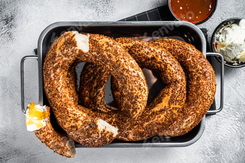 Preview: Homemade baked Turkish simit or Gevrek bagel with kaymak and honey. Gray background. Top view