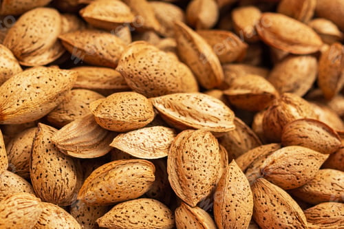 Preview: Background of unpeeled almonds in the shell.