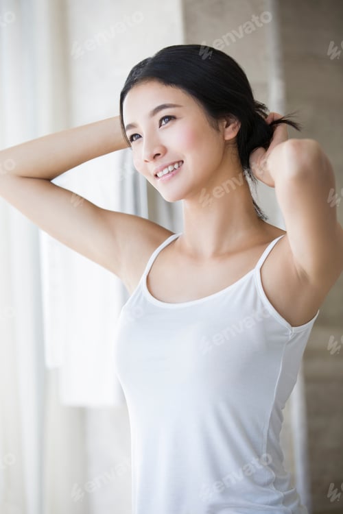 Preview: Young woman tying up her hair