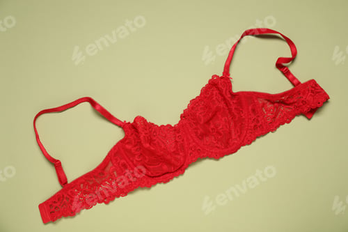 Preview: Beautiful red lace bra on light green background, top view