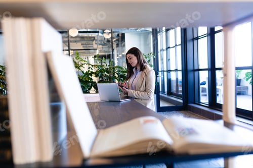 Preview: Caucasian woman working on her laptop in modern office