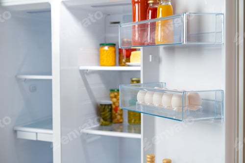 Preview: Glass jars of canned products on a fridge shelf