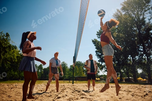 Preview: Group of friends playing volleyball on the beach.