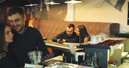Preview: A Beautiful Couple Makes An Order In A Bar. An Attractive Man And A Girl Are Sitting At A Table In