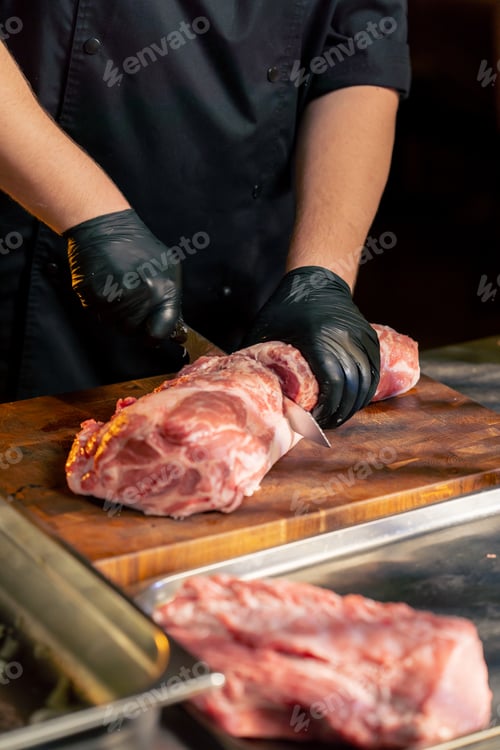 Preview: close up in a restaurant in a rib bar in the central hall, a chef in black gloves cuts large piece