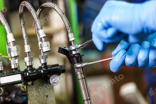 Preview: Professional mechanic testing diesel injector in his workshop.