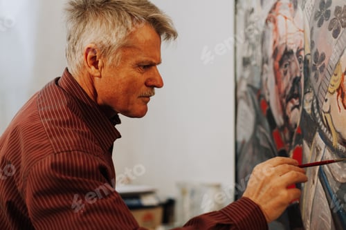 Preview: Old man artist painting oils in his studio.