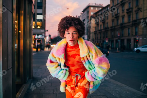 Preview: Stylish black young woman posing outdoors at night looking camera fashionable cool attitude
