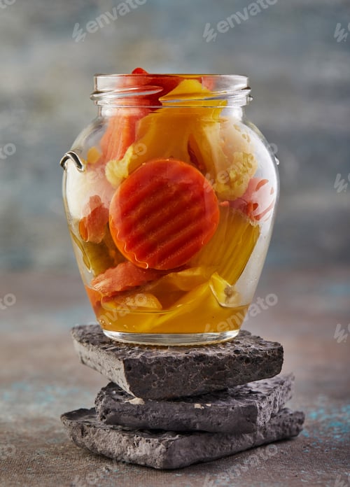 Preview: Fermented vegetarian canned food concept. Pickled carrots and broccoli in a glass jar.