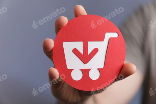 Preview: Closeup shot of a man holding a red and white shopping cart icon on a grey background