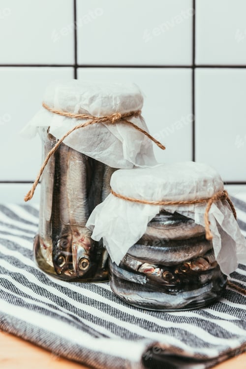 Preview: Pile of salted fish in jars wrapped by strings on towel