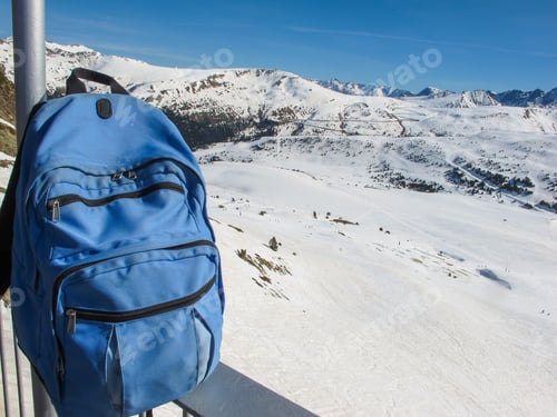 Preview: A blue backpack against the mountain's landscape and bright blue sky. Travel content