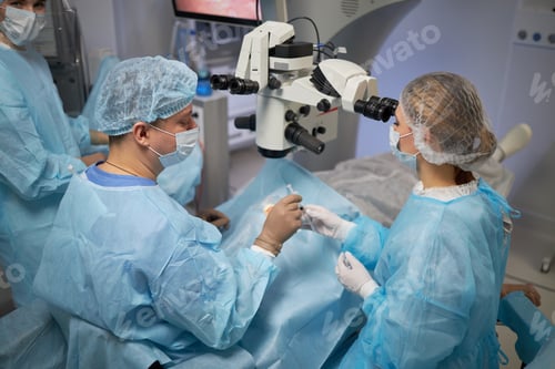 Preview: Male Surgeon Performing Operation with Female Assistant in Operating Room