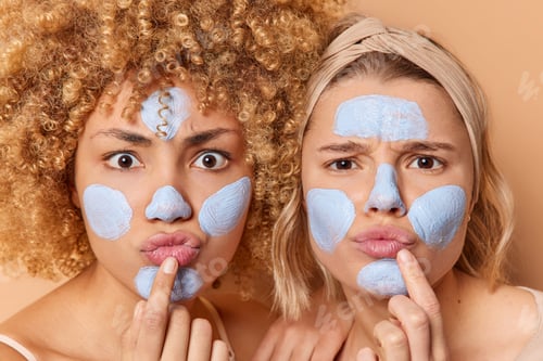 Preview: Photo of serious women focused attentively at camera pout lips and gaze scrupulously apply beauty ma